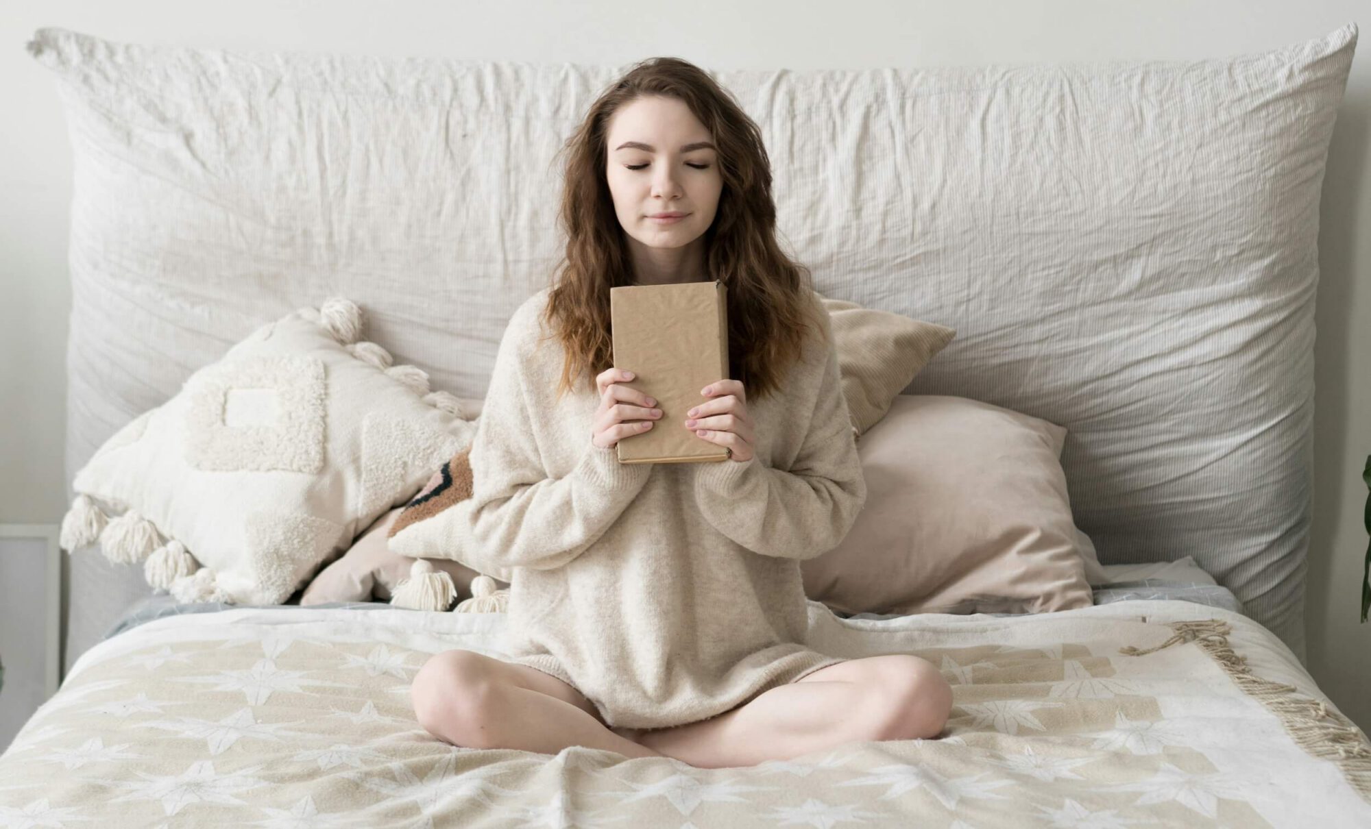 femme sur son lit tenant un carnet