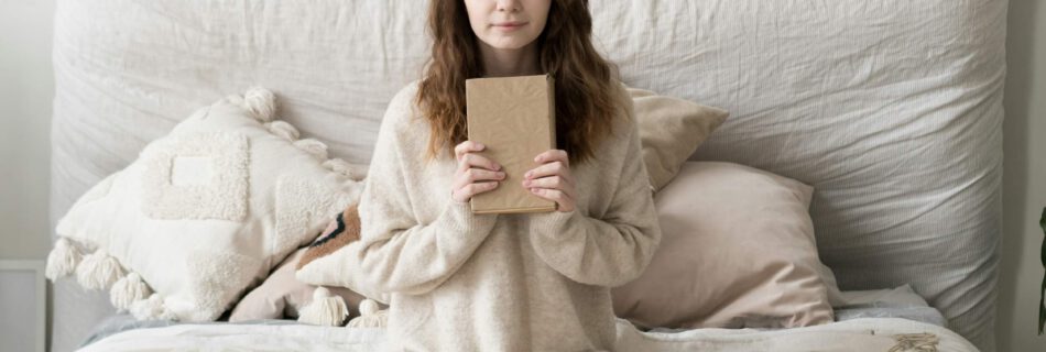 femme sur son lit tenant un carnet