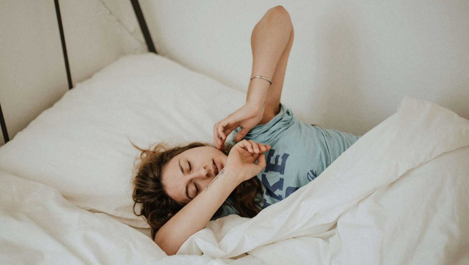 femme s'étirant dans son lit